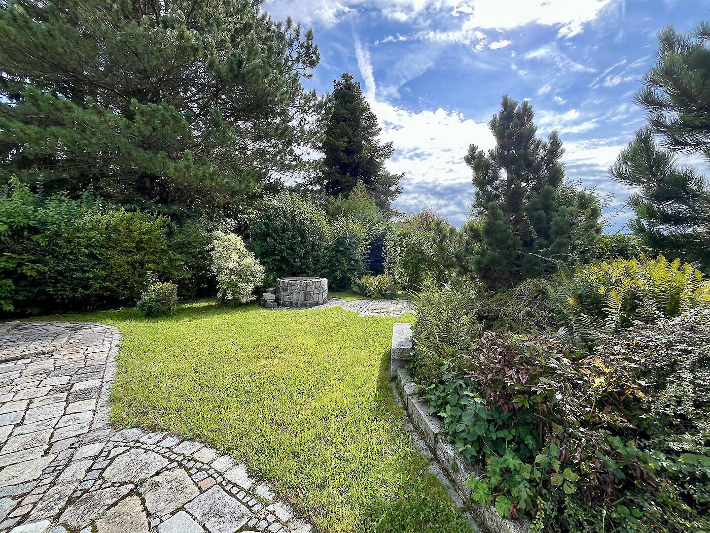Blick auf Beet und Grundwasserbrunnen